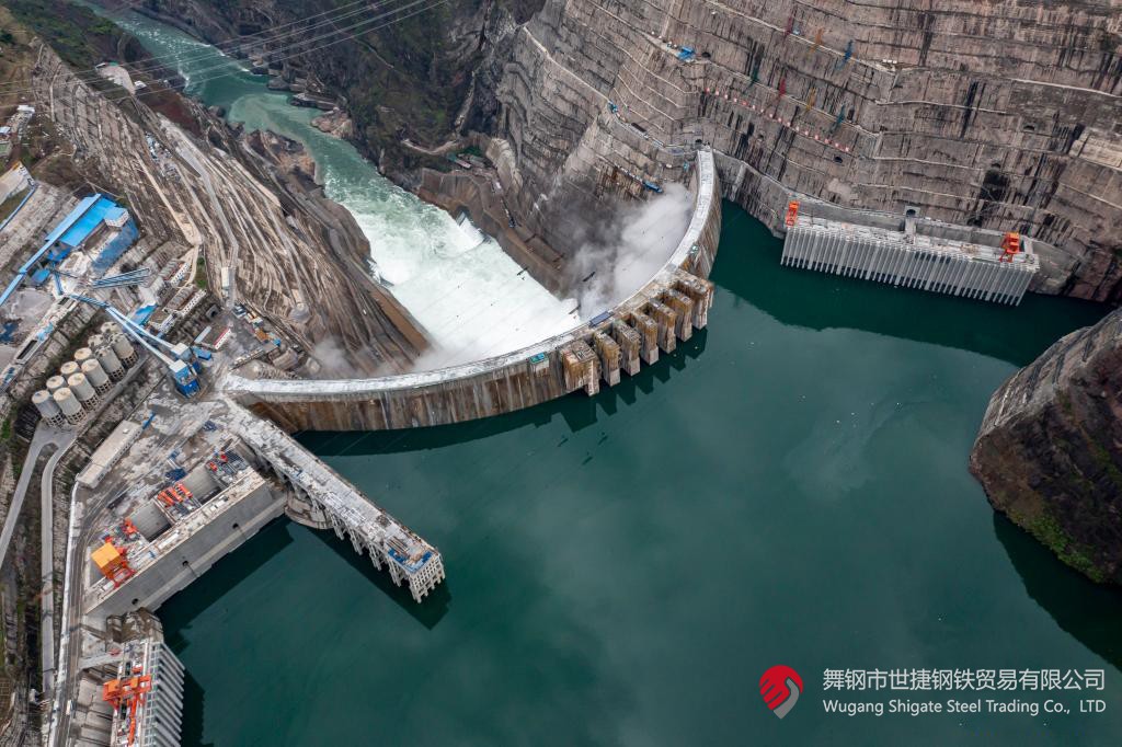 10月24日下午，白鶴灘水電站右岸地下廠房最后一倉封頂混凝土澆筑完成，標志著世界在建最大水電站地下廠房全線封頂。在該工程建設中，河鋼集團舞鋼公司累計生產(chǎn)供應Q500、Q345C/B、SX780等數(shù)個新品種鋼板4500噸，主要用于水電站水輪機座環(huán)、發(fā)電機頂蓋、控制環(huán)、壓力鋼管制造，大大加速了大型發(fā)電機組用鋼國產(chǎn)化進程。    據(jù)介紹，白鶴灘水電站位于四川省涼山州和云南省昭通市交界處，是世界在建規(guī)模最大的水電工程，裝機總容量1600萬千瓦，其左右岸地下廠房內(nèi)分別布置8臺具有完全自主知識產(chǎn)權的單機容量達100萬千瓦的水輪發(fā)電機組，單機容量位居世界第一。10月24日下午，白鶴灘水電站成功蓄水至825米高程，首次達到正常水位，大壩將接受高水位全面檢驗。    該工程的規(guī)模天然決定了其施工難度極高，復雜的地形地質(zhì)條件和技術指標等因素也給施工帶來了巨大挑戰(zhàn)。因此在電站建設材料及關鍵部位用鋼的選擇上，客戶慎之又慎，對焊接性能、韌性、強度等均有著極為嚴苛的技術要求。舞鋼公司憑借強大的質(zhì)量品牌優(yōu)勢和雄厚的技術實力成功中標——數(shù)百噸“舞鋼牌”高技術含量的大厚度高級別水電鋼板用于制造世界單機容量最大的巨型水輪發(fā)電機組的座環(huán)。    隨后，舞鋼公司為白鶴灘水電站定制研發(fā)265mm厚的SXQ500D-Z35鋼板，并進一步制作加工件。公司科技部高強鋼研究所針對該鋼的生產(chǎn)重點和難點，提前制定措施，并在冶煉、制坯等關鍵環(huán)節(jié)派人進行跟蹤、協(xié)調(diào)。在科技、設備、生產(chǎn)人員的共同努力下，該批鋼板最終順利生產(chǎn)完畢。鋼板及試樣經(jīng)公司、客戶和第三方檢驗機構檢驗合格后，在三和盛機建公司完成切割深加工。    交付客戶后，該鋼憑著焊接性能好、力學結構良好、低溫沖擊韌性強等優(yōu)點，承受住了巨大的水壓力和沖擊負荷，再次贏得設備制造方的高度評價。（舞鋼市委宣傳部 楊德坤 張培軍）